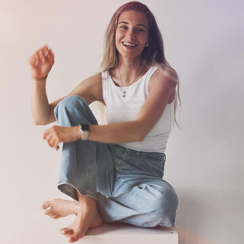 Deetje lächelt, während sie sitzt.